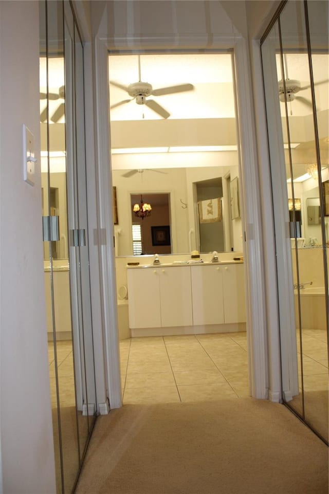 hallway featuring light tile patterned floors and an inviting chandelier