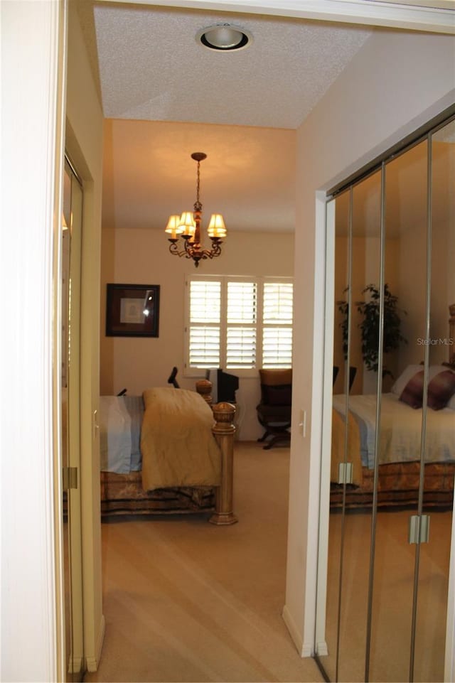 bedroom with light colored carpet, a closet, and a notable chandelier