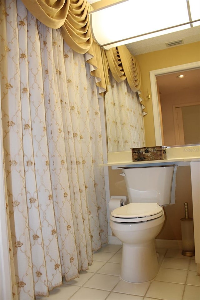 bathroom featuring toilet and tile patterned flooring