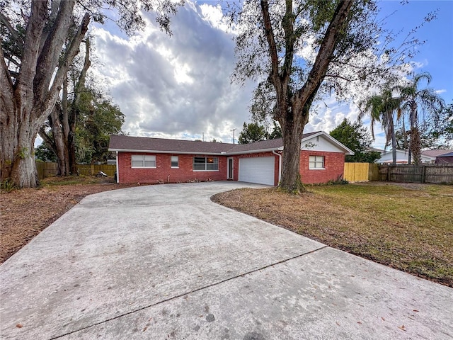 single story home with a garage and a front lawn