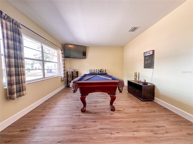 game room featuring pool table, light hardwood / wood-style floors, and a textured ceiling