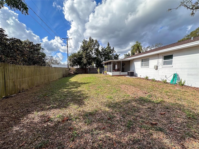 view of yard with central AC unit and a sunroom