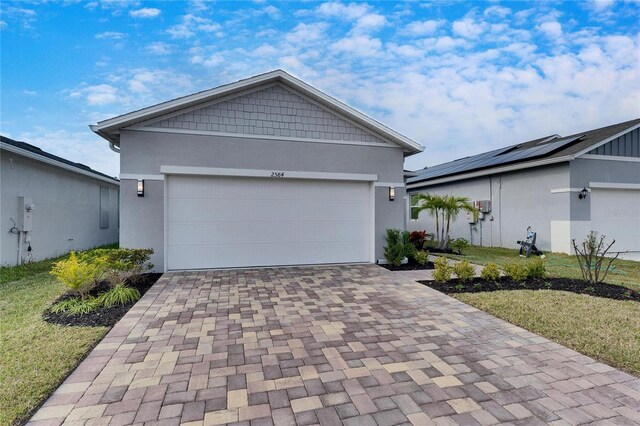 ranch-style home featuring a garage and a front lawn