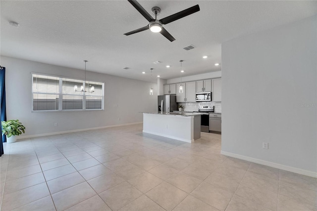 unfurnished living room featuring light tile patterned floors, ceiling fan with notable chandelier, and a textured ceiling