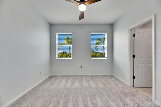 empty room with light colored carpet and ceiling fan