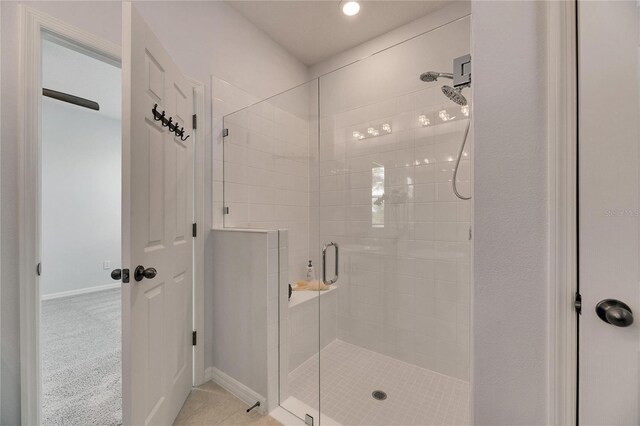 bathroom with tile patterned flooring and a shower with door