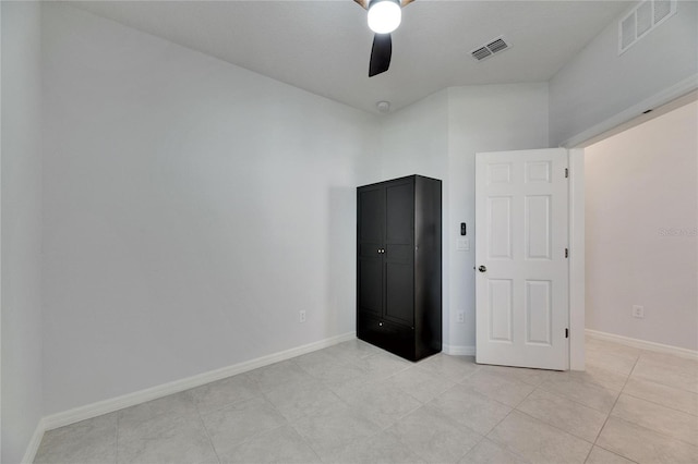 tiled empty room with a high ceiling and ceiling fan