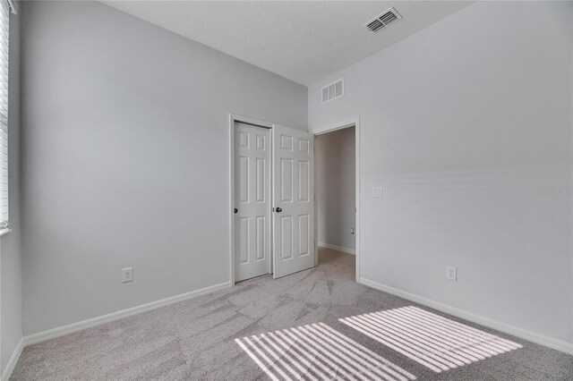 carpeted spare room with a textured ceiling