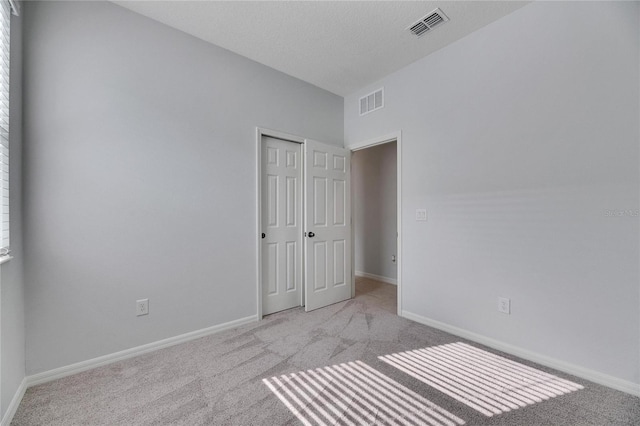 carpeted empty room with a textured ceiling