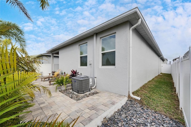 rear view of property featuring cooling unit and a patio area