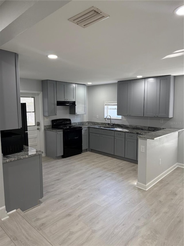 kitchen featuring sink, electric range, gray cabinets, light hardwood / wood-style floors, and plenty of natural light