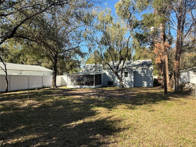 view of yard featuring central air condition unit and a sunroom