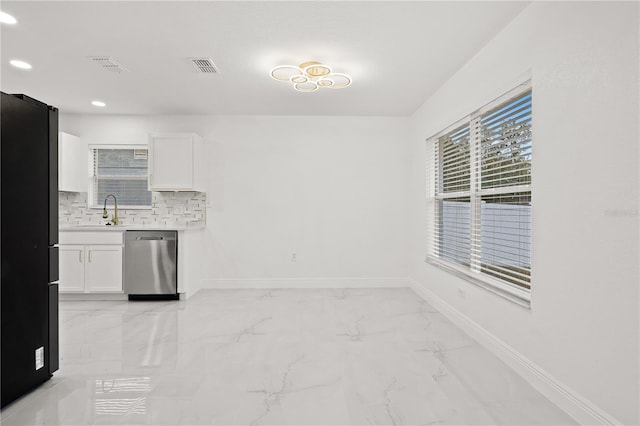 kitchen with dishwasher, tasteful backsplash, white cabinetry, and black refrigerator