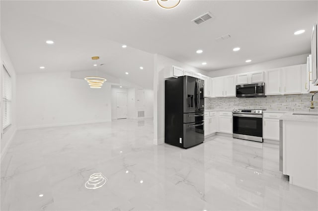 kitchen with stainless steel appliances, white cabinetry, lofted ceiling, and sink