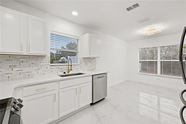 kitchen featuring dishwasher, stove, sink, tasteful backsplash, and white cabinetry