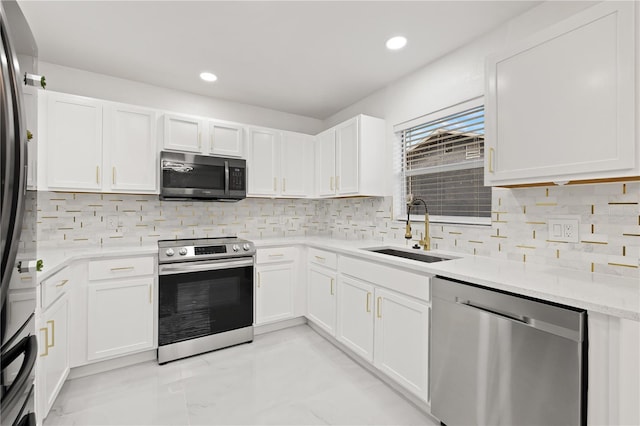 kitchen with white cabinetry, sink, stainless steel appliances, and light stone counters