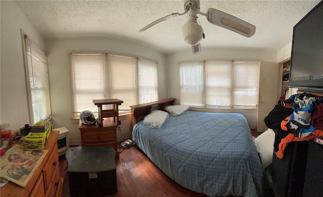 bedroom featuring a textured ceiling, ceiling fan, dark hardwood / wood-style flooring, and lofted ceiling