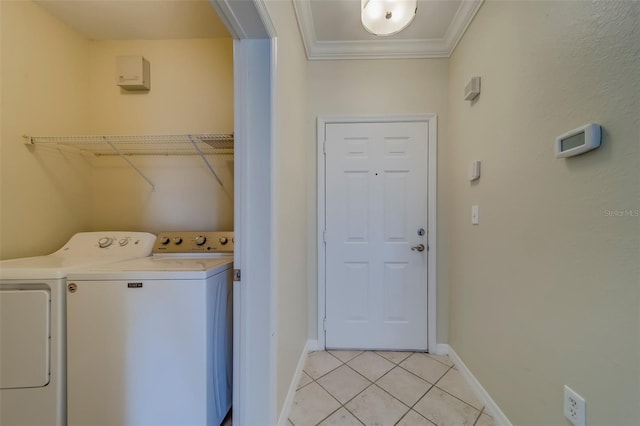 laundry room with light tile patterned flooring, washing machine and dryer, and ornamental molding