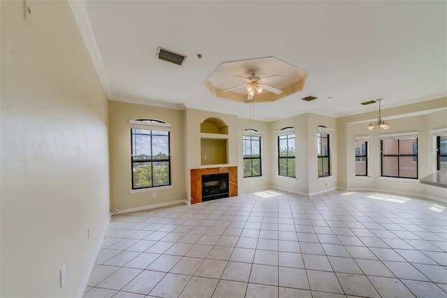 unfurnished living room featuring ceiling fan with notable chandelier, built in shelves, light tile patterned flooring, and crown molding