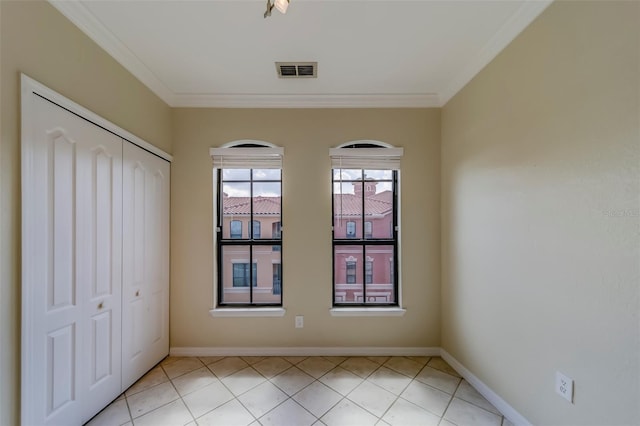 tiled spare room featuring ornamental molding