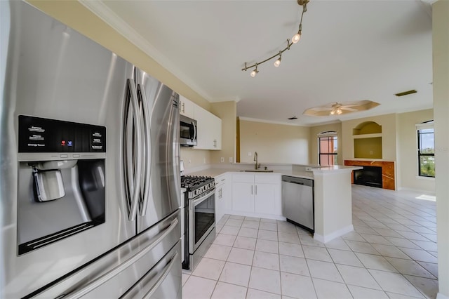 kitchen featuring stainless steel appliances, kitchen peninsula, ceiling fan, sink, and white cabinetry