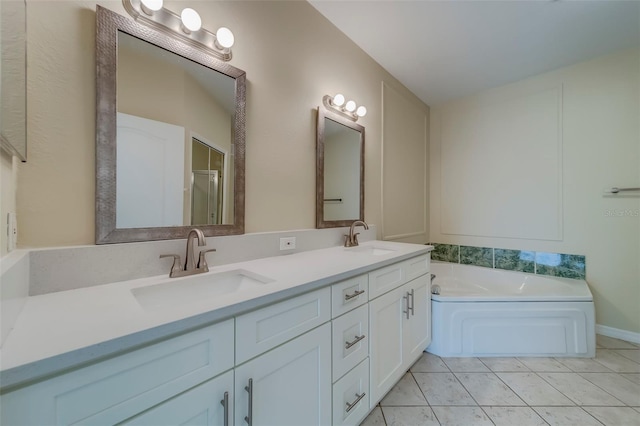 bathroom with a tub to relax in, tile patterned flooring, and vanity