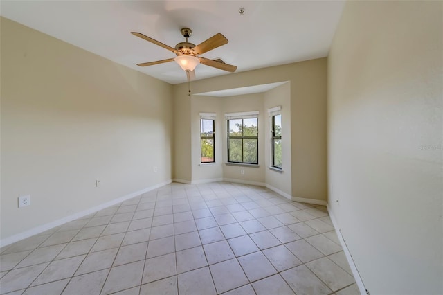 tiled empty room featuring ceiling fan