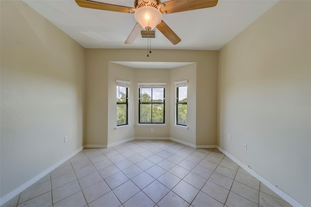 tiled empty room featuring ceiling fan