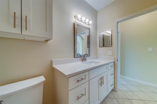 bathroom with tile patterned flooring, vanity, and toilet