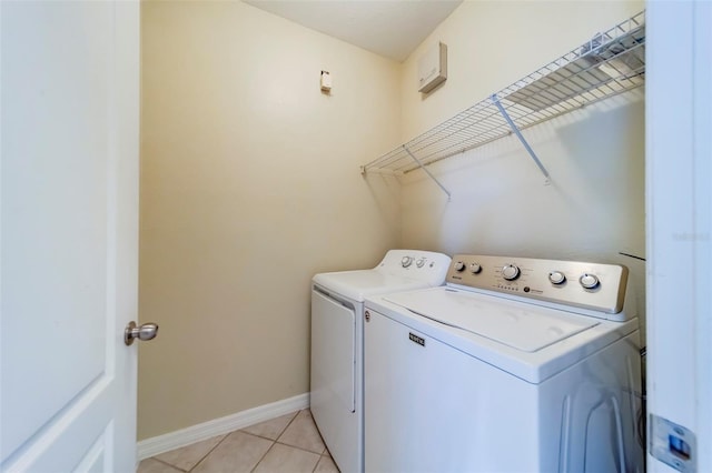 clothes washing area featuring light tile patterned flooring and washing machine and clothes dryer