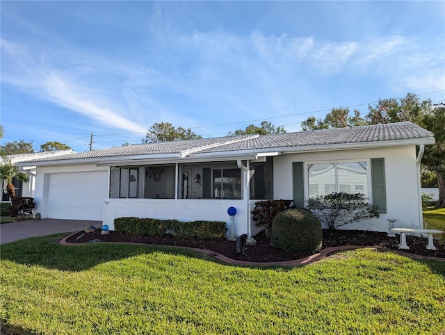 ranch-style home with a sunroom, a front lawn, and a garage