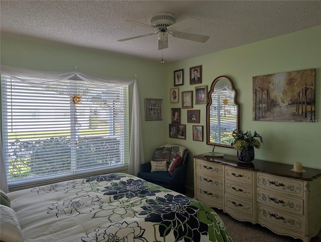 bedroom featuring ceiling fan, carpet floors, and a textured ceiling