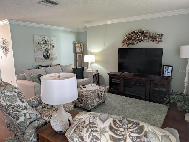 living area with wood finished floors, visible vents, and crown molding