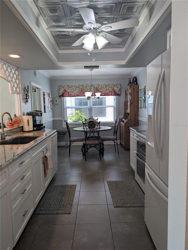 kitchen featuring double oven range, a tray ceiling, a sink, and freestanding refrigerator