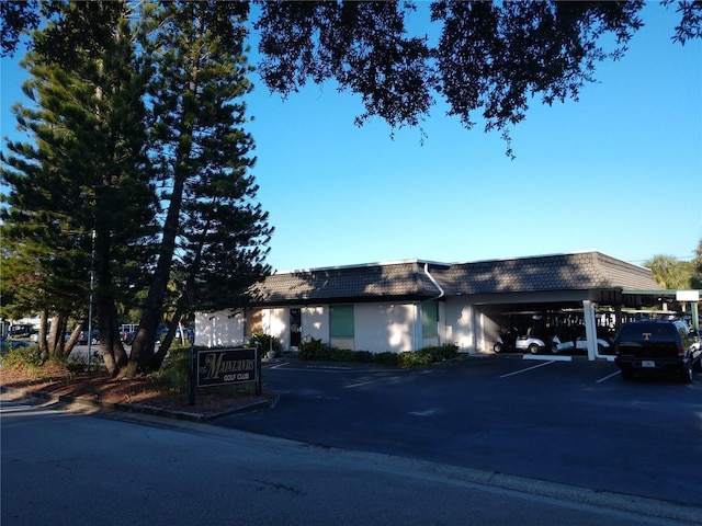 view of front of home with covered parking and mansard roof