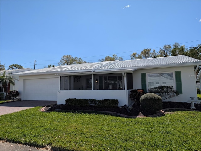 ranch-style home featuring a front yard, decorative driveway, an attached garage, and stucco siding