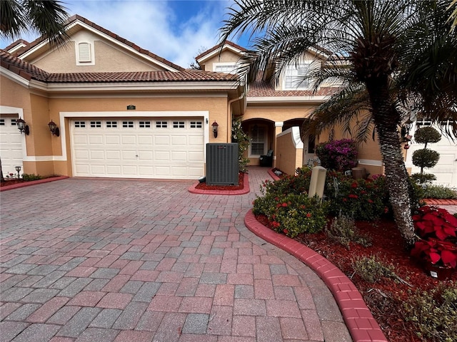 mediterranean / spanish-style home with cooling unit and a garage