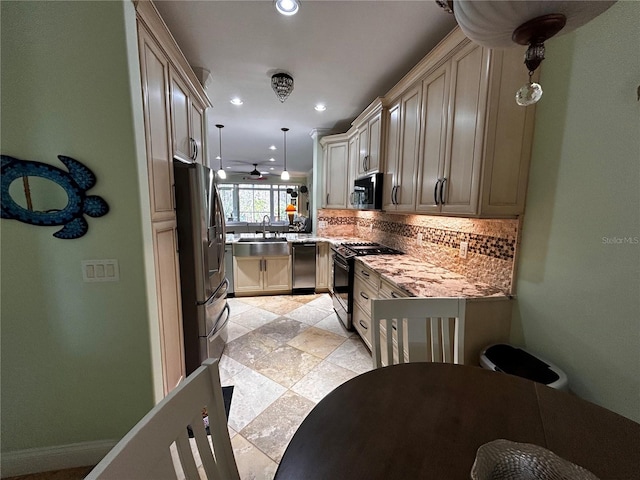 kitchen featuring sink, decorative backsplash, light stone countertops, decorative light fixtures, and stainless steel appliances