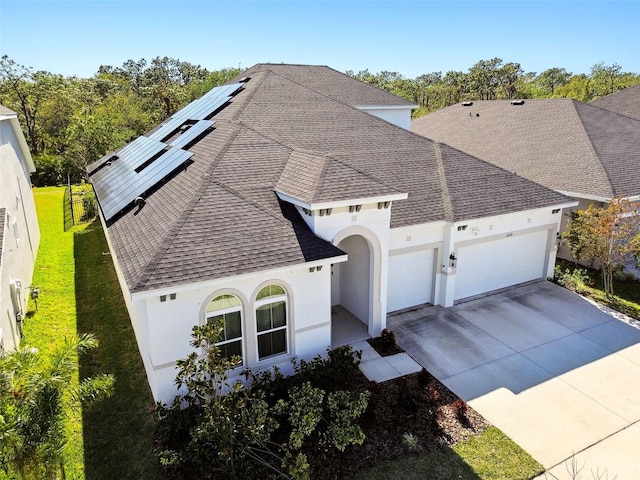 view of front facade featuring a garage, a front yard, and solar panels