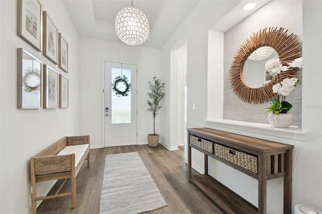 entrance foyer with dark hardwood / wood-style flooring and a notable chandelier