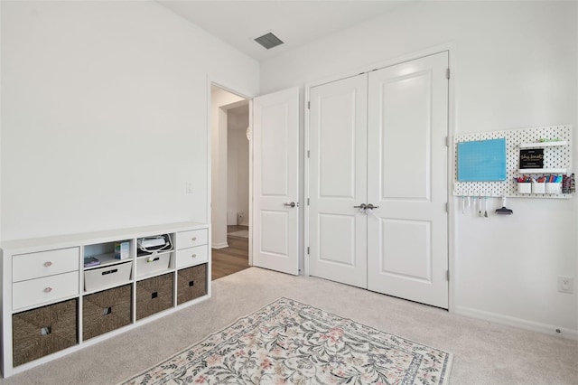 bedroom with light carpet and a closet