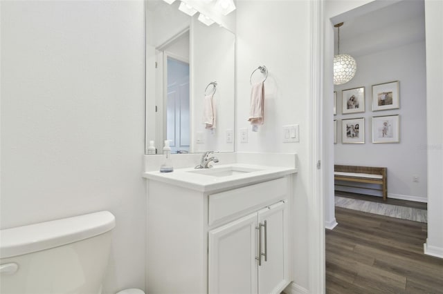 bathroom featuring hardwood / wood-style flooring, vanity, and toilet