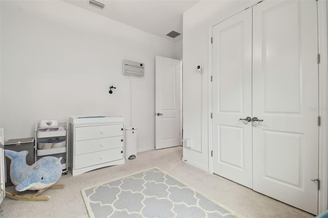 bedroom featuring light colored carpet and a closet