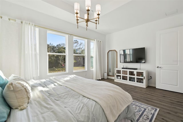 bedroom featuring a chandelier and dark hardwood / wood-style flooring