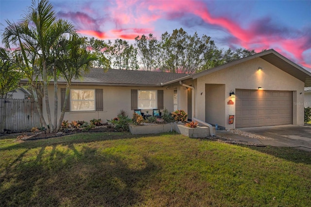 ranch-style house with a garage and a yard