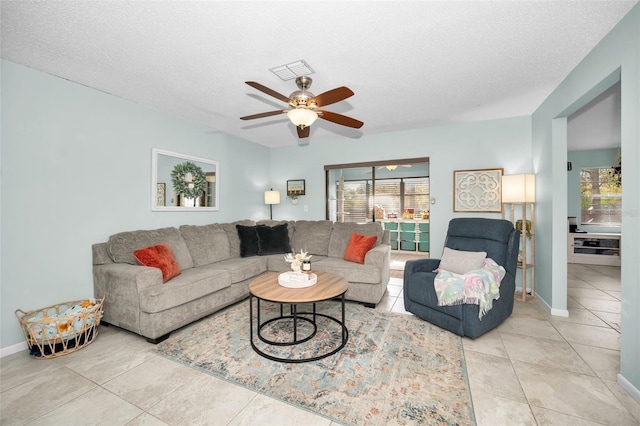 tiled living room featuring a textured ceiling and ceiling fan