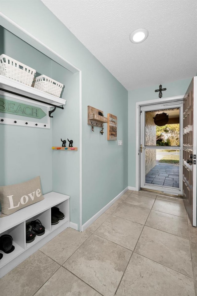 mudroom featuring tile patterned floors and a textured ceiling