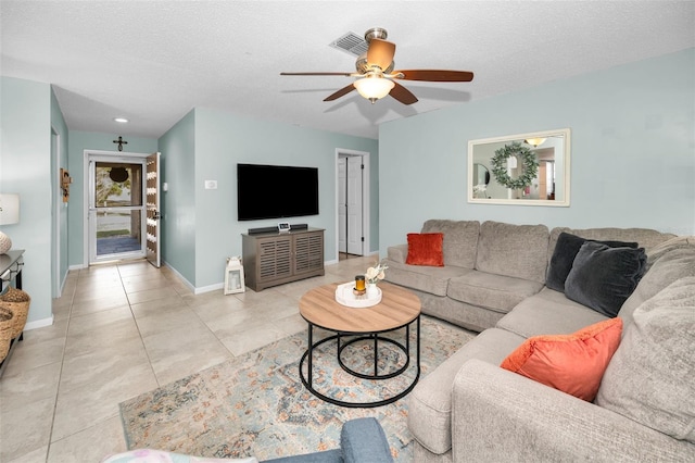 tiled living room featuring ceiling fan and a textured ceiling