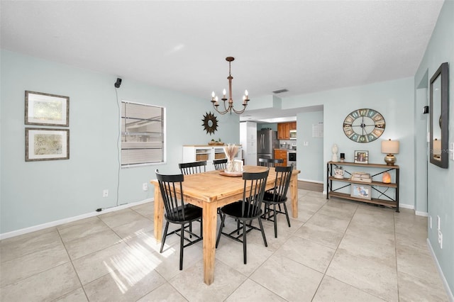 dining space featuring a notable chandelier and light tile patterned floors