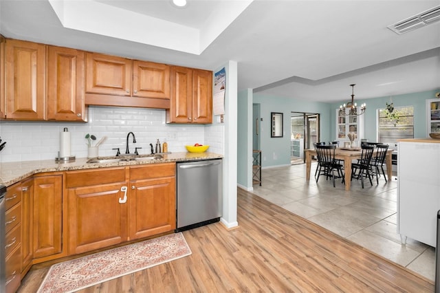 kitchen with sink, light hardwood / wood-style flooring, stainless steel dishwasher, a chandelier, and decorative light fixtures